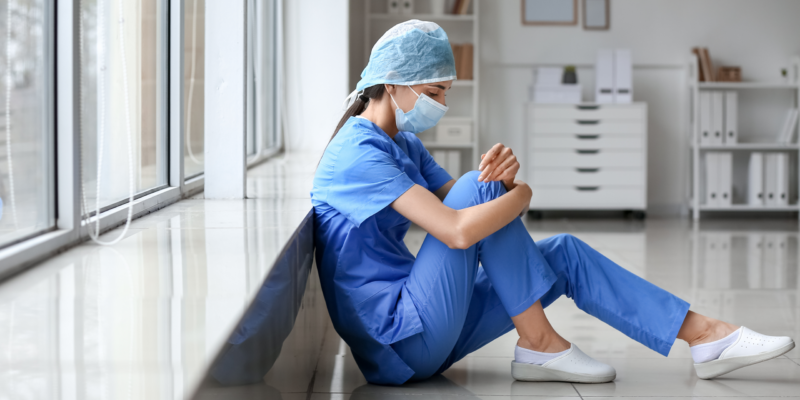 Veterinary-surgeon-sitting-on-floor-stressed